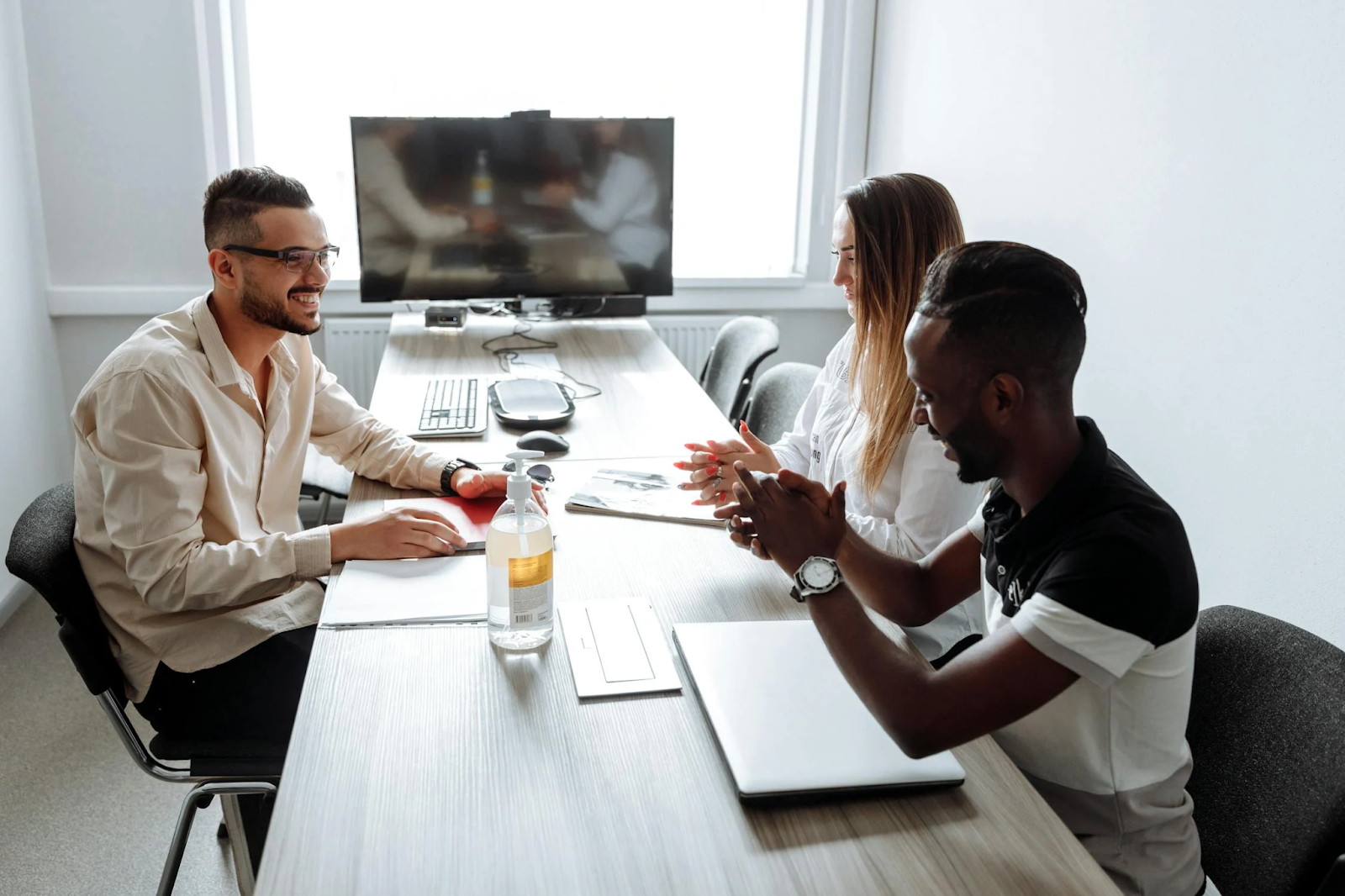 Three diverse coworkers meet together at the office to discuss DEI training