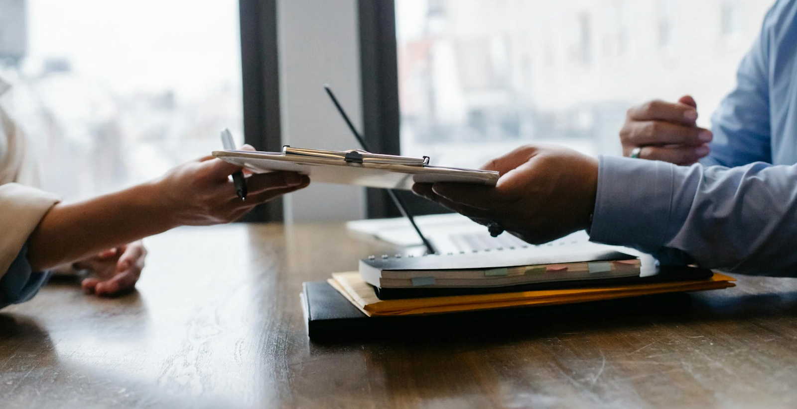 An employee hands over a clipboard