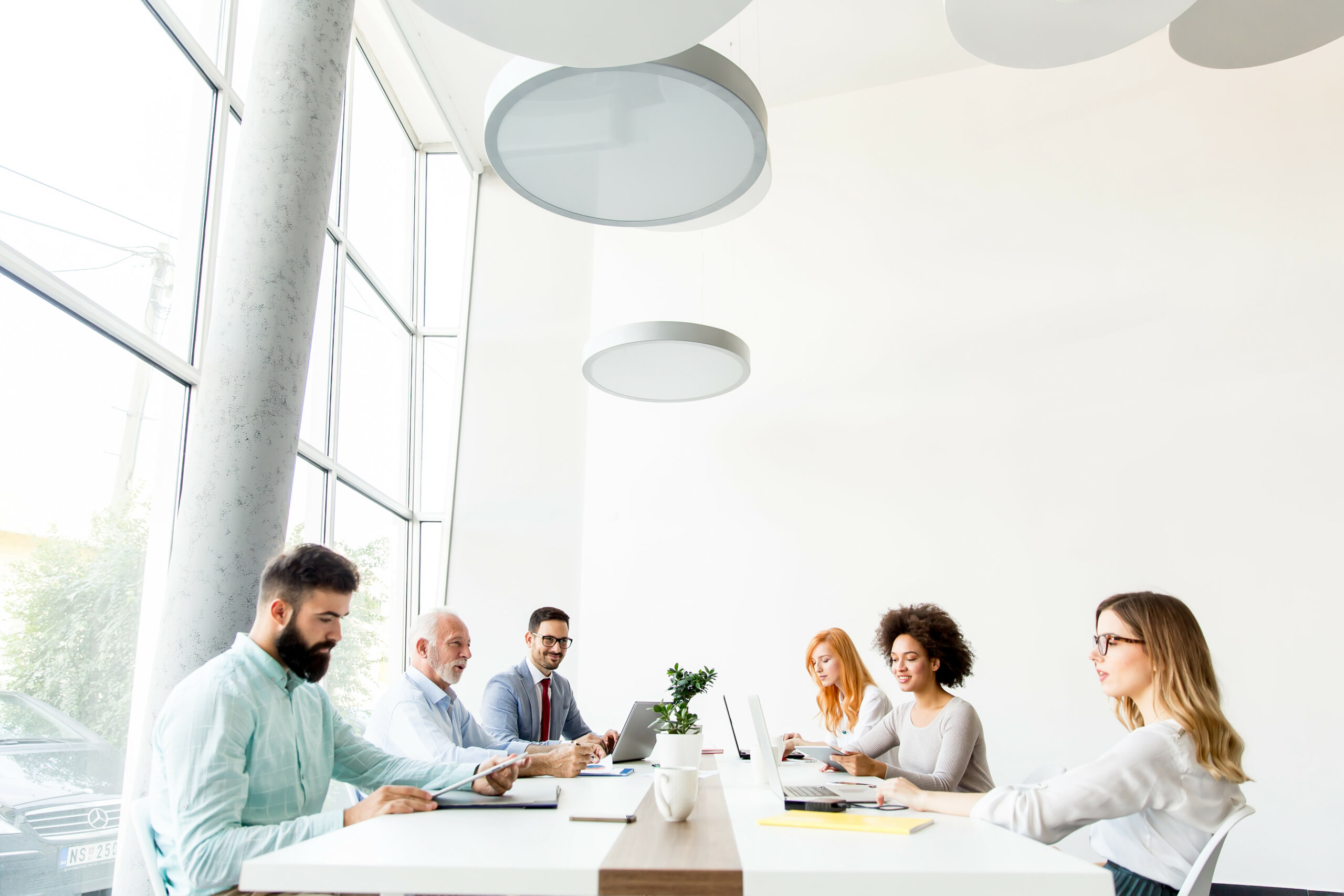 A Group Of Employees Going Over Business Strategy With Their HR Representative In A Modern Conference Room