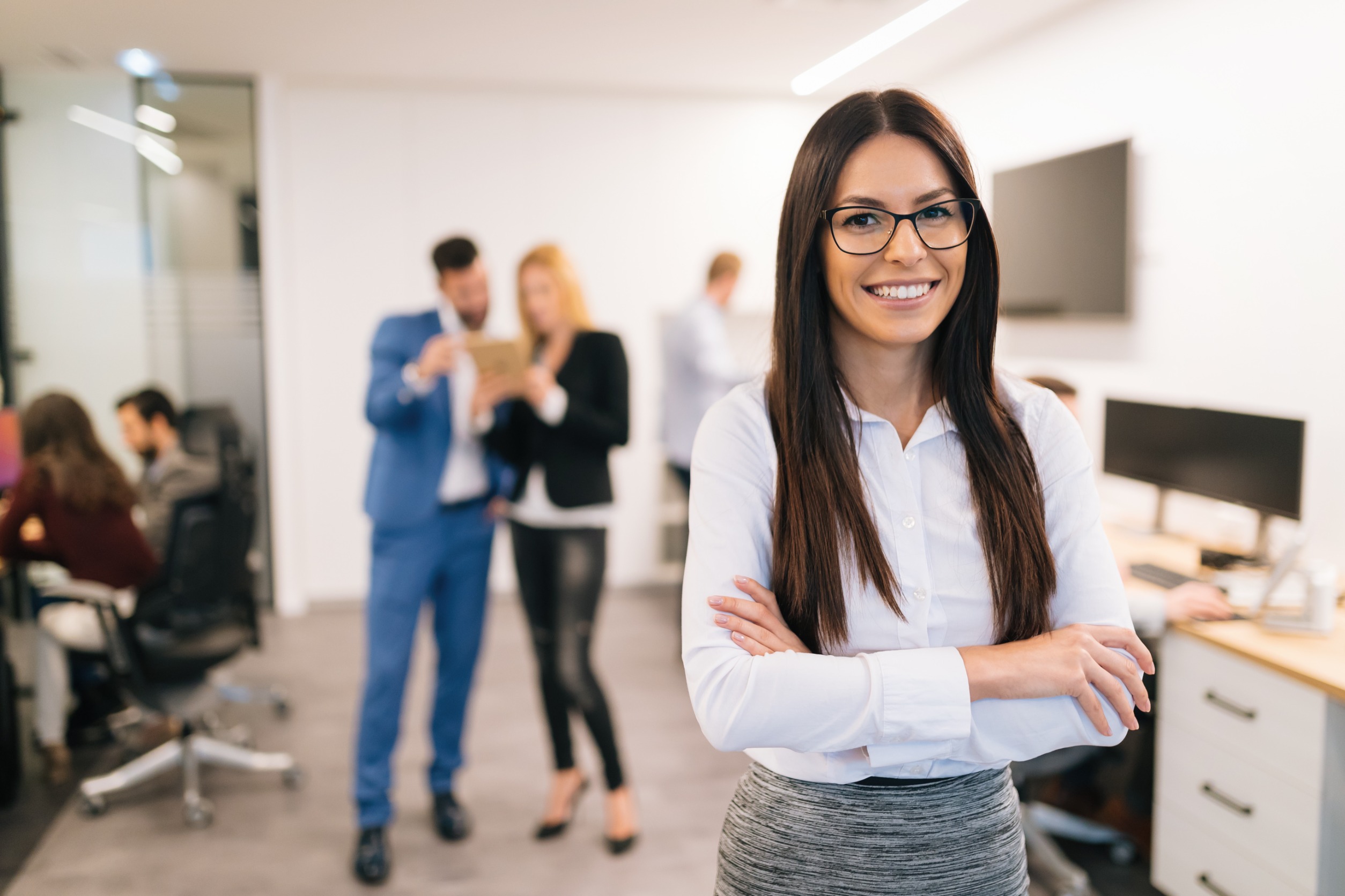 A Smiling HR Representative With Coworkers In The Background