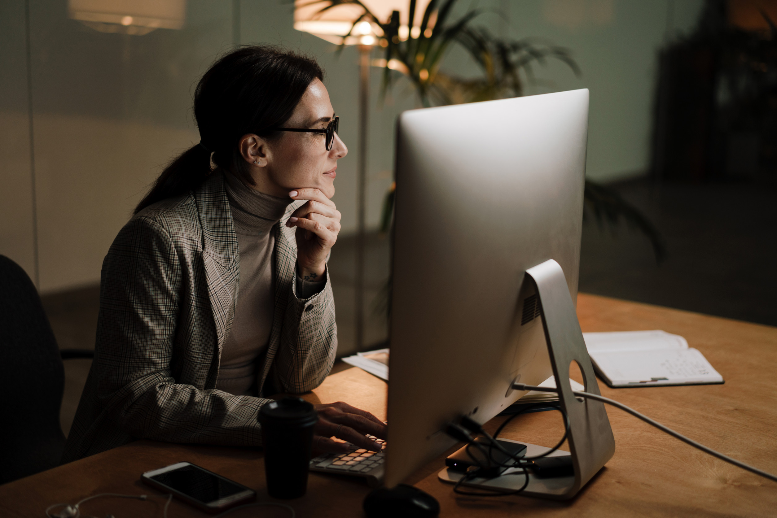 A Young Happy Woman Recently Certified In HR Sitting At Her New Desk In Her Office With A Computer Monitor