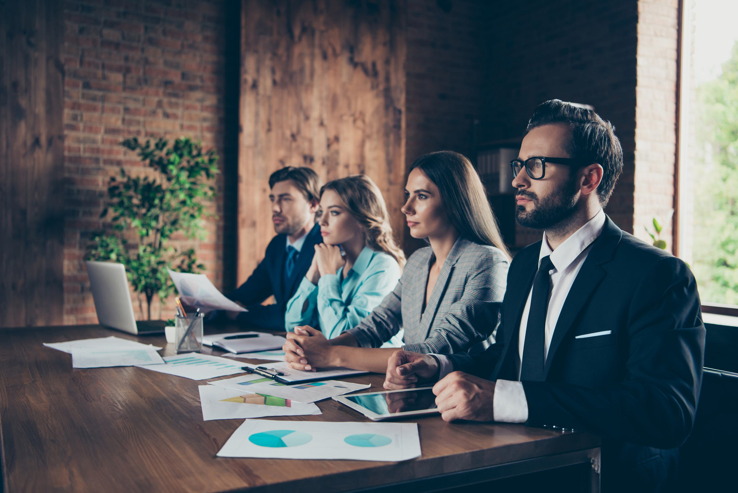 A Group Of HR Professionals Sitting At A Table Discussing HR Strategy